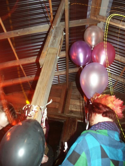some balloons hanging from the ceiling in front of the people