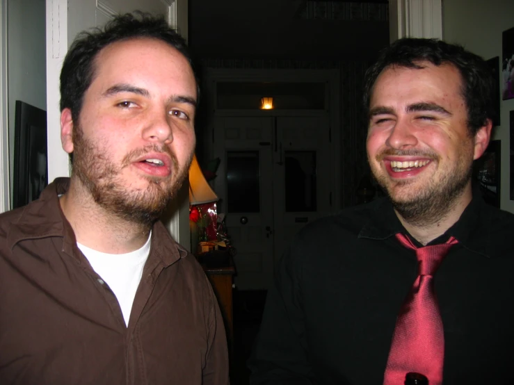 two men are sitting next to each other wearing neckties