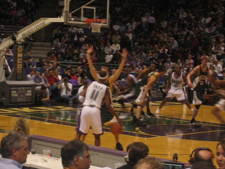 several men playing basketball against each other in a court