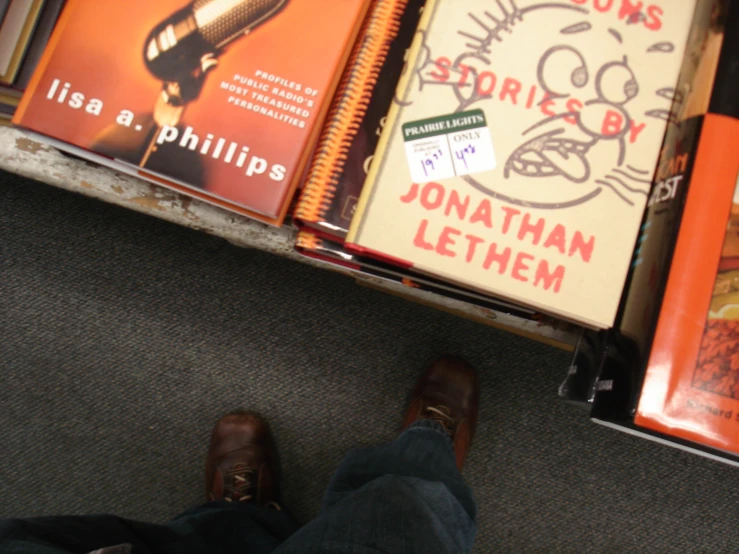 a person standing near some books on a table