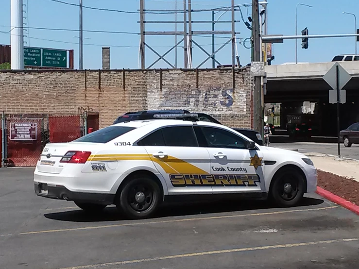 police car parked in parking lot near train tracks