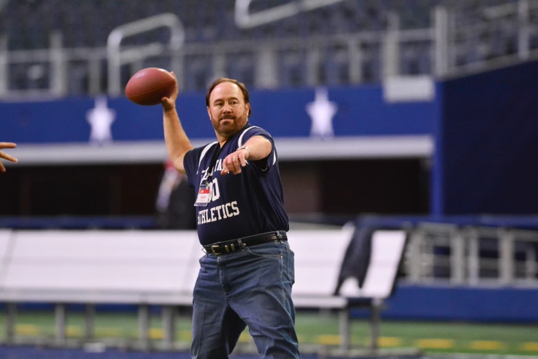 a man with an arm out trying to catch a ball