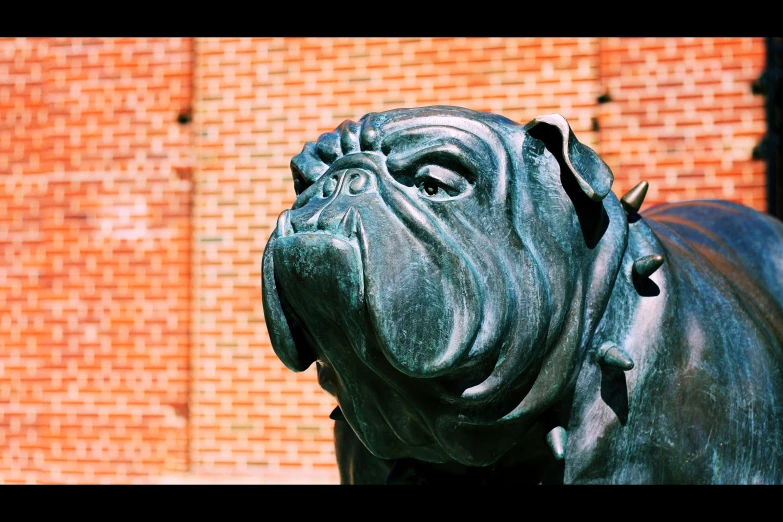 a close - up of a dog statue near a brick wall