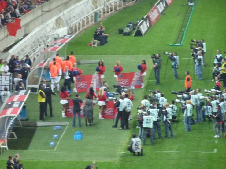 people on the field standing around holding signs