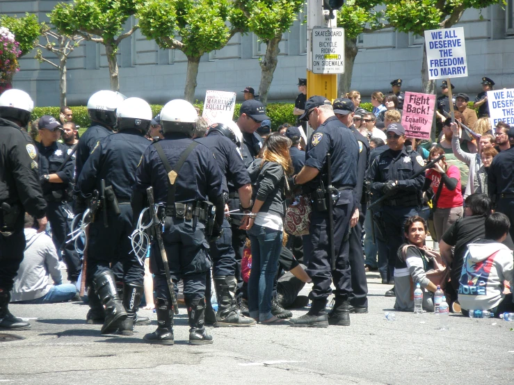two cops are talking to a crowd of protesters