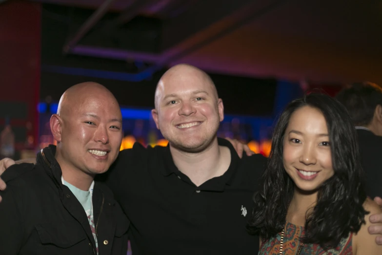 three people posing for the camera at a party