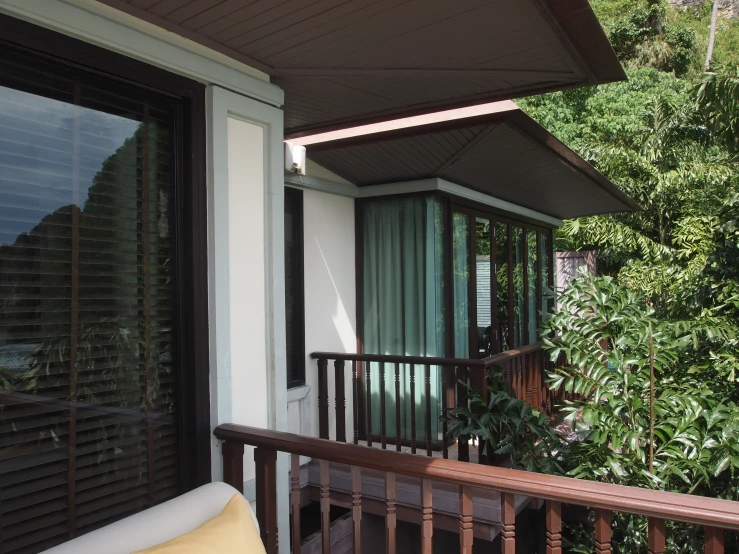 an open window next to a brown wooden railing