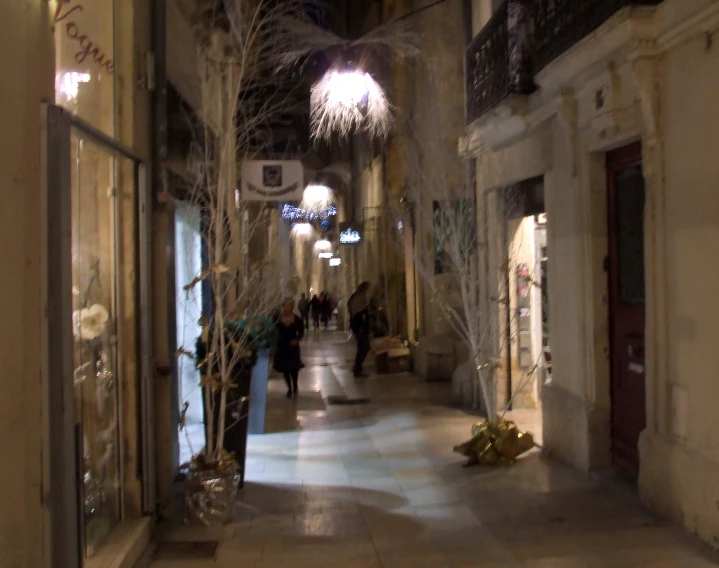 a long hallway in an old building with chandeliers hanging from the ceiling