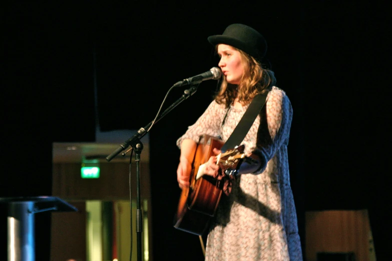 a woman singing into a microphone on top of a stage