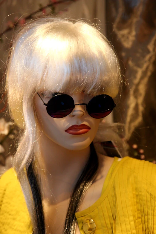 a mannequin wearing black sunglasses is wearing a yellow dress