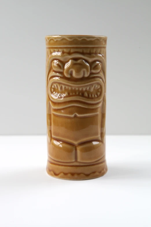 a close up of a brown ceramic object with designs on the top