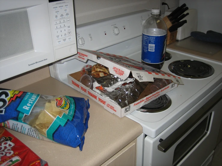 two boxes of food sitting next to a stove top oven