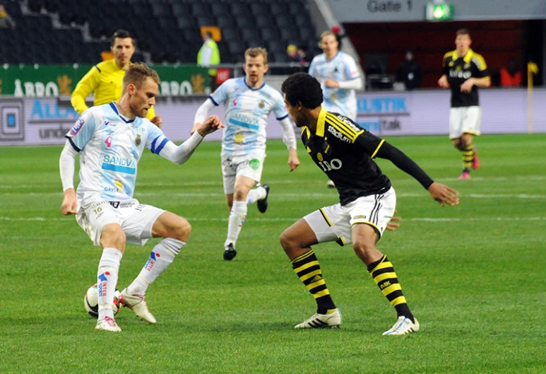 several men playing soccer on a field with other people