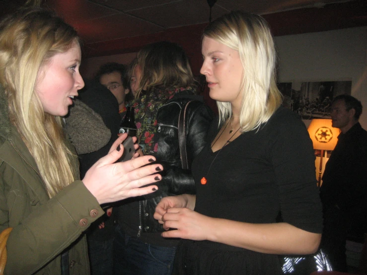 two beautiful young blond women standing next to each other