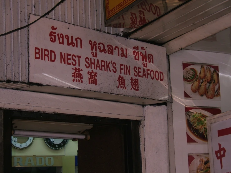 the side of a building with signs saying that the bird nest sparks fin seafood is right in front of it