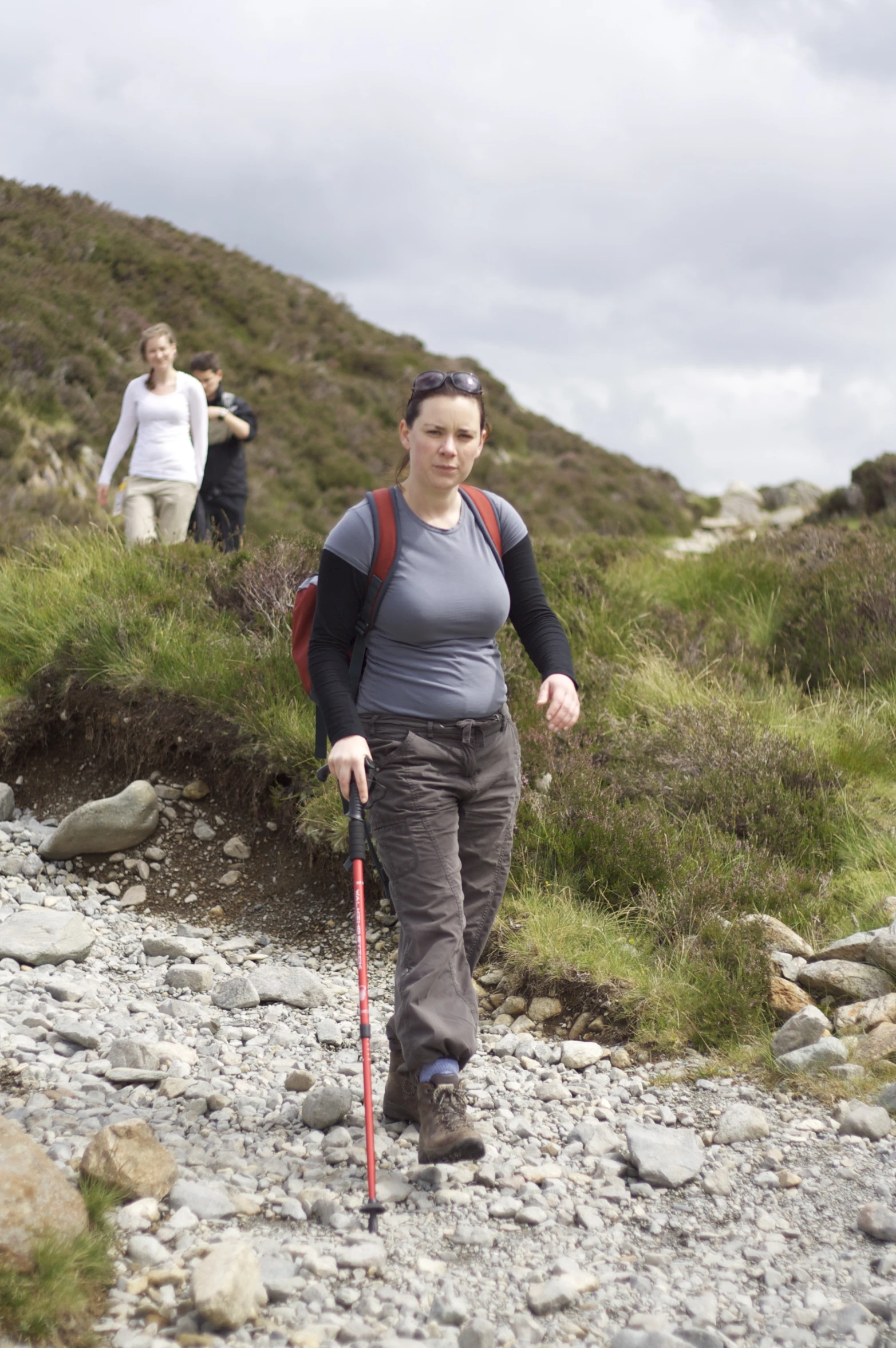 a woman with trek poles in a rocky area