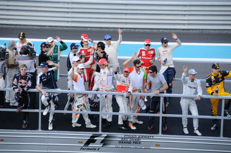 the race team waves at the crowd during a practice session