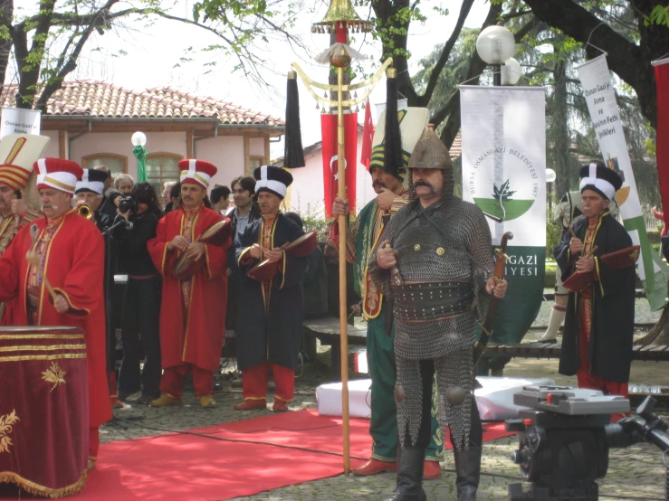 a man in a costume with a sword and lots of people