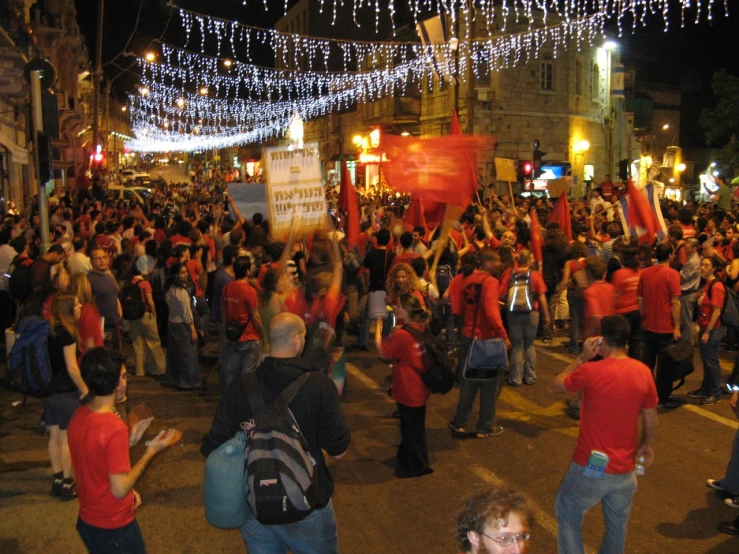 the people are holding banners and wearing red