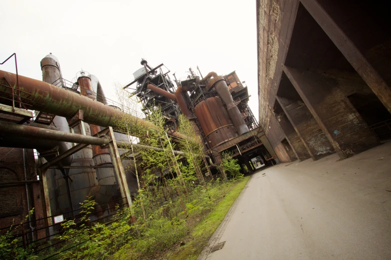 an empty road leading to an old factory