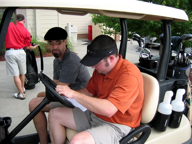 a group of men who are sitting in a golf cart