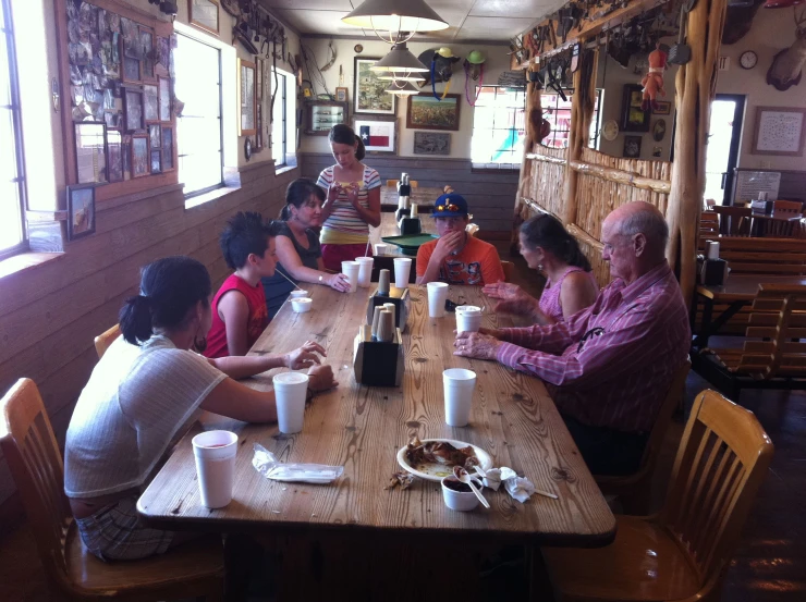 a large group of people sitting at a table in a restaurant