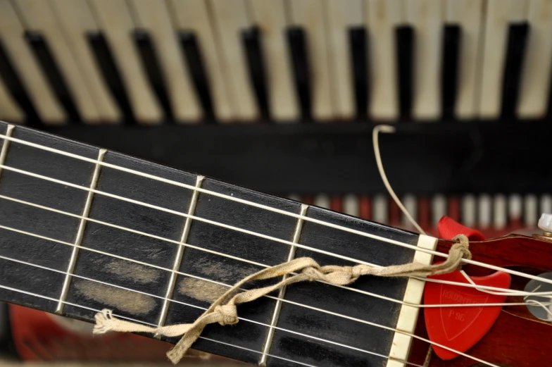 close up of a guitar neck with strings and a small red fret