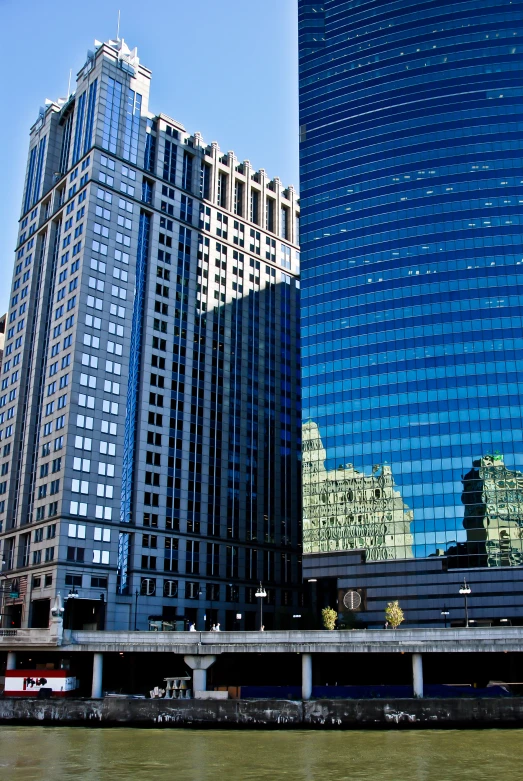 skyscrs in the city are reflected in water