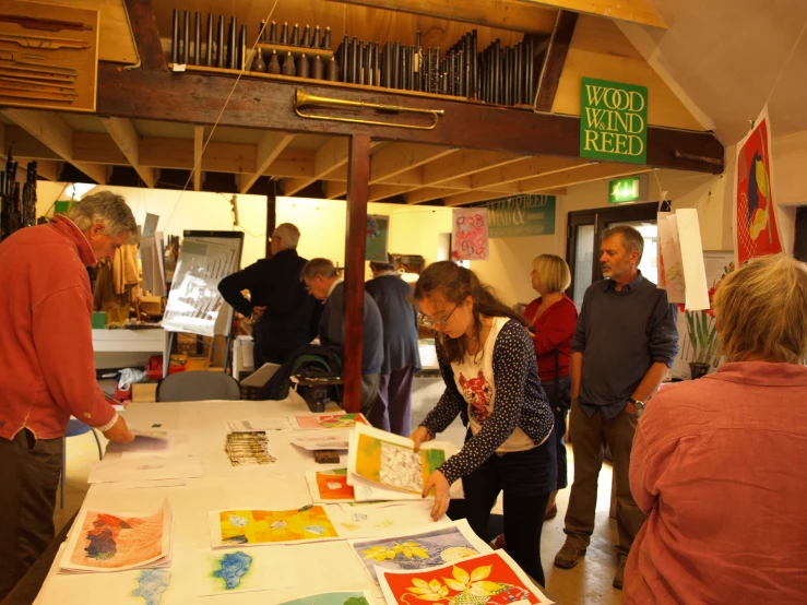 several people are gathered around a table in a wood and paper store