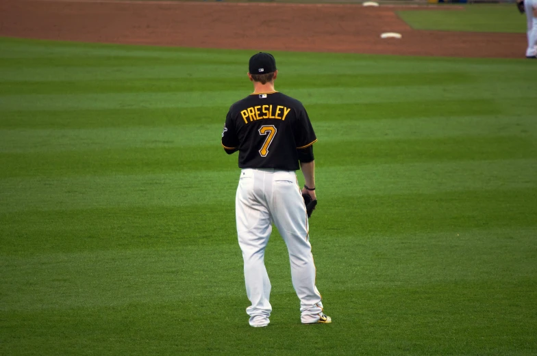 a baseball player in uniform standing on the field with his arm in the pocket