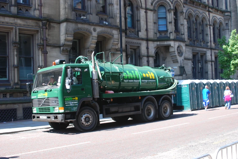 a green truck in front of a building