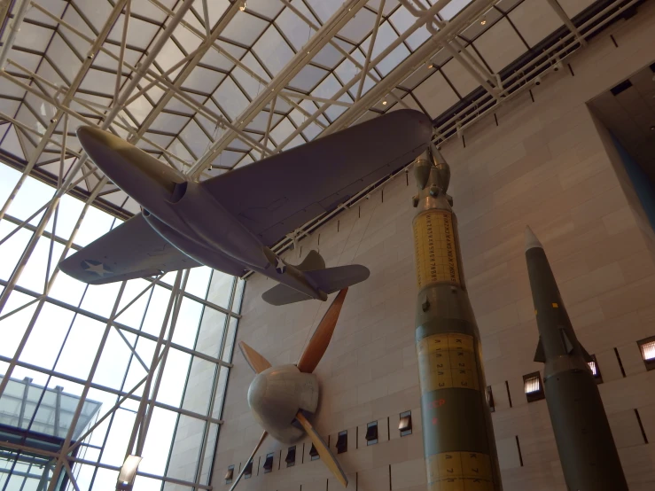 some airplanes are hanging up inside of a museum