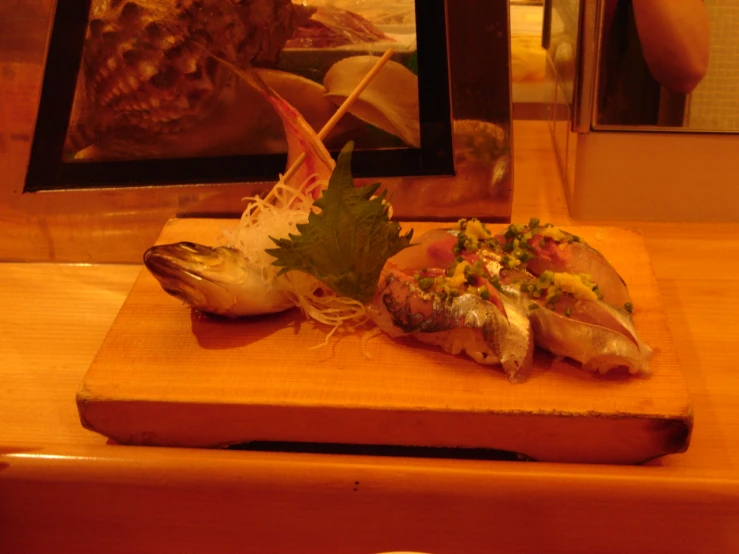 fish with vegetables and garnishes sitting on  board