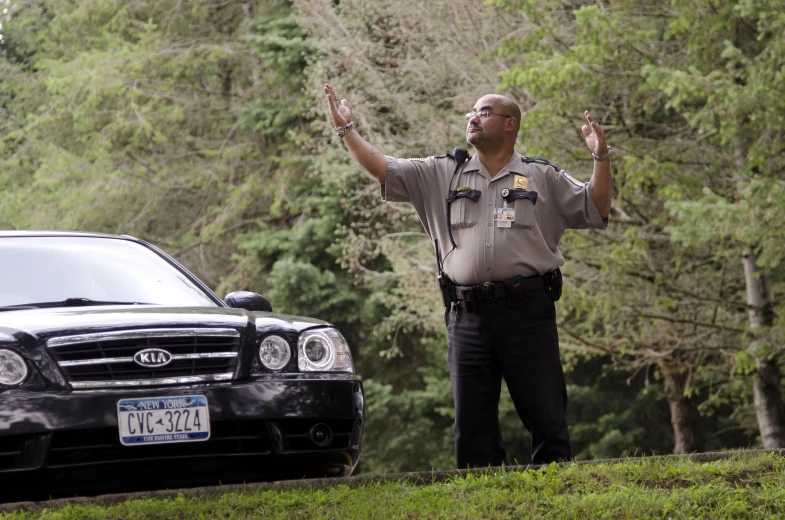 a police officer standing next to his car on the side of the road