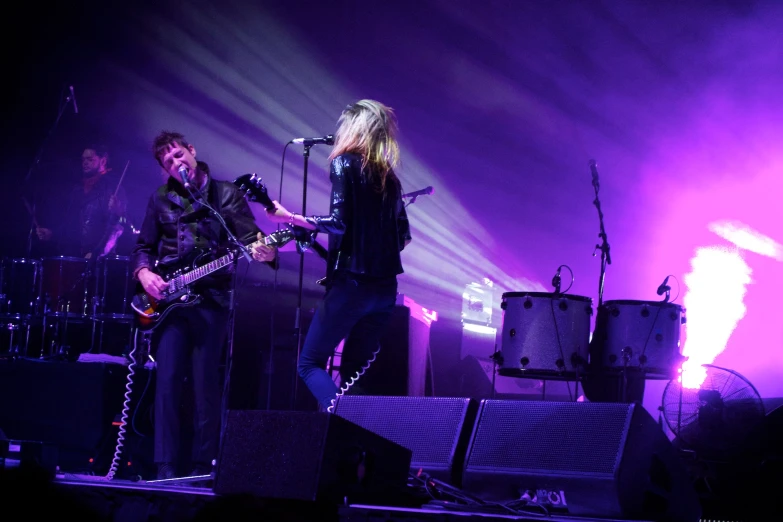 two people with guitars singing at a concert