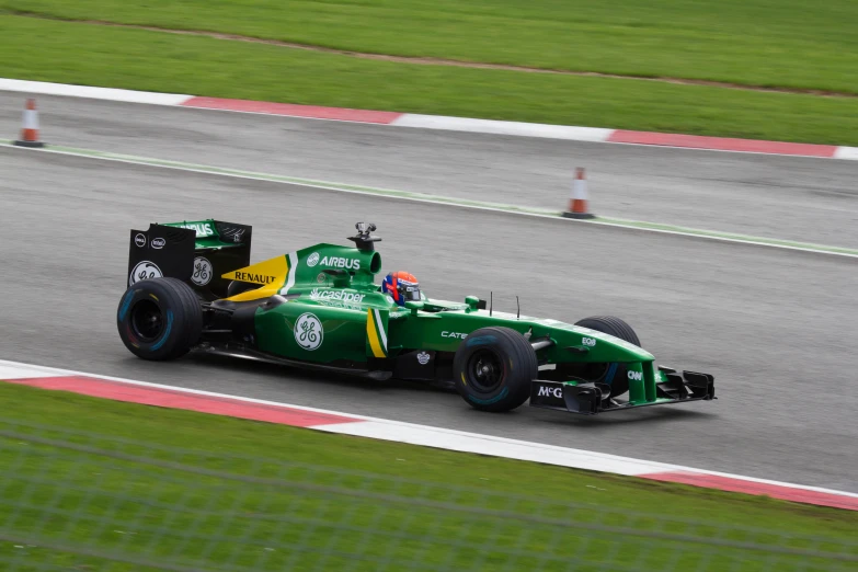 a green race car is driving on the track