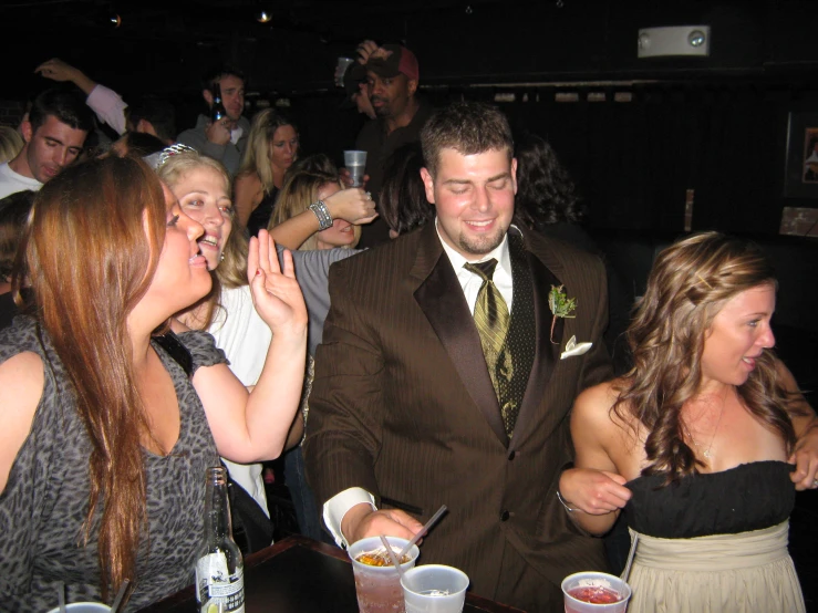 a man in a tuxedo smiles for the camera at the party