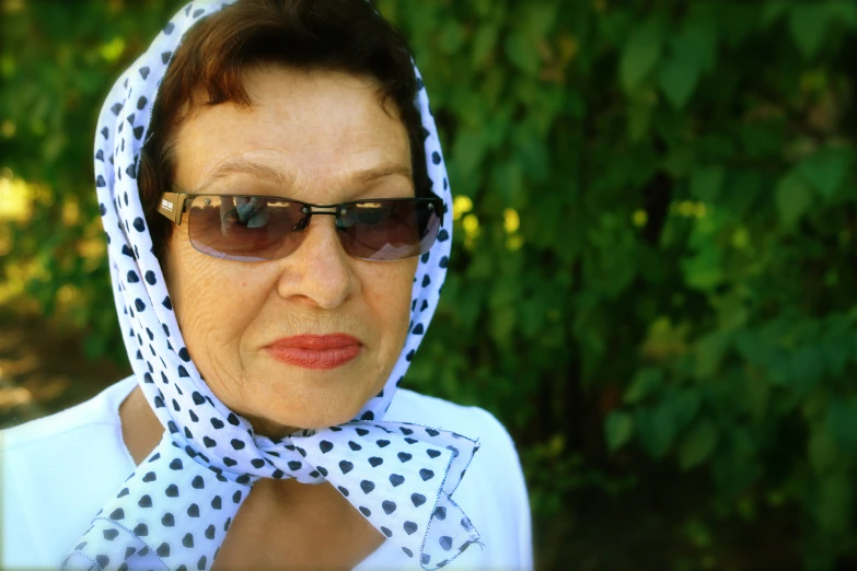 a woman is wearing glasses and a polka dot head scarf