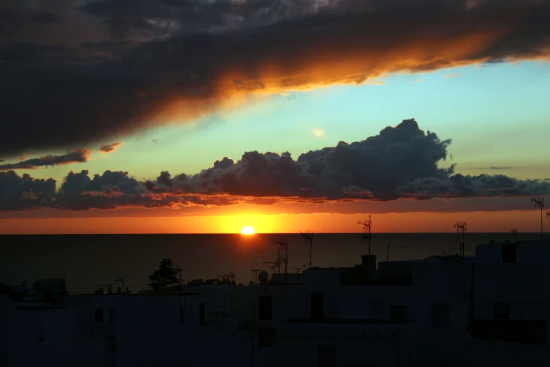 the sun is setting in the distance with clouds in the background