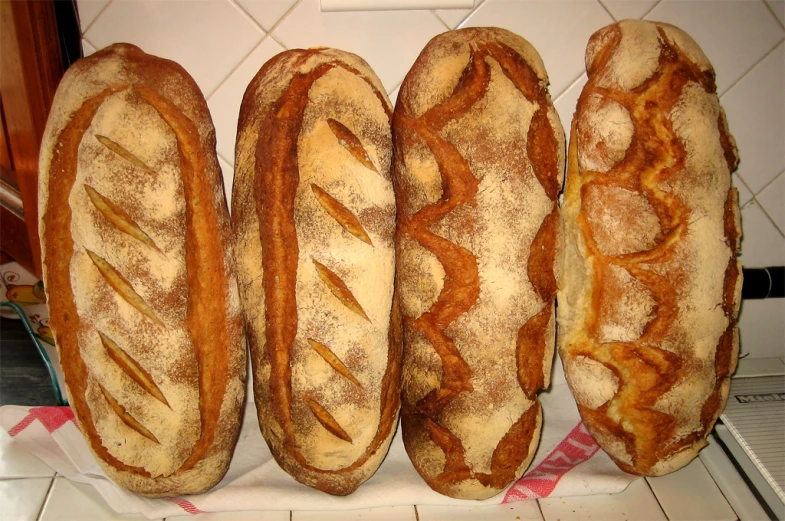 a bunch of loaves of bread sitting on top of a counter