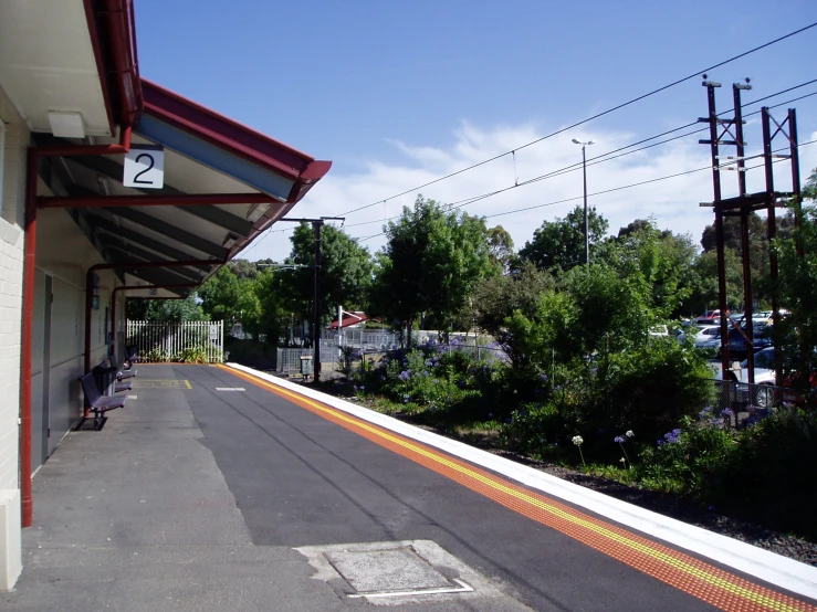 a bus stop with a red and white painted street and road