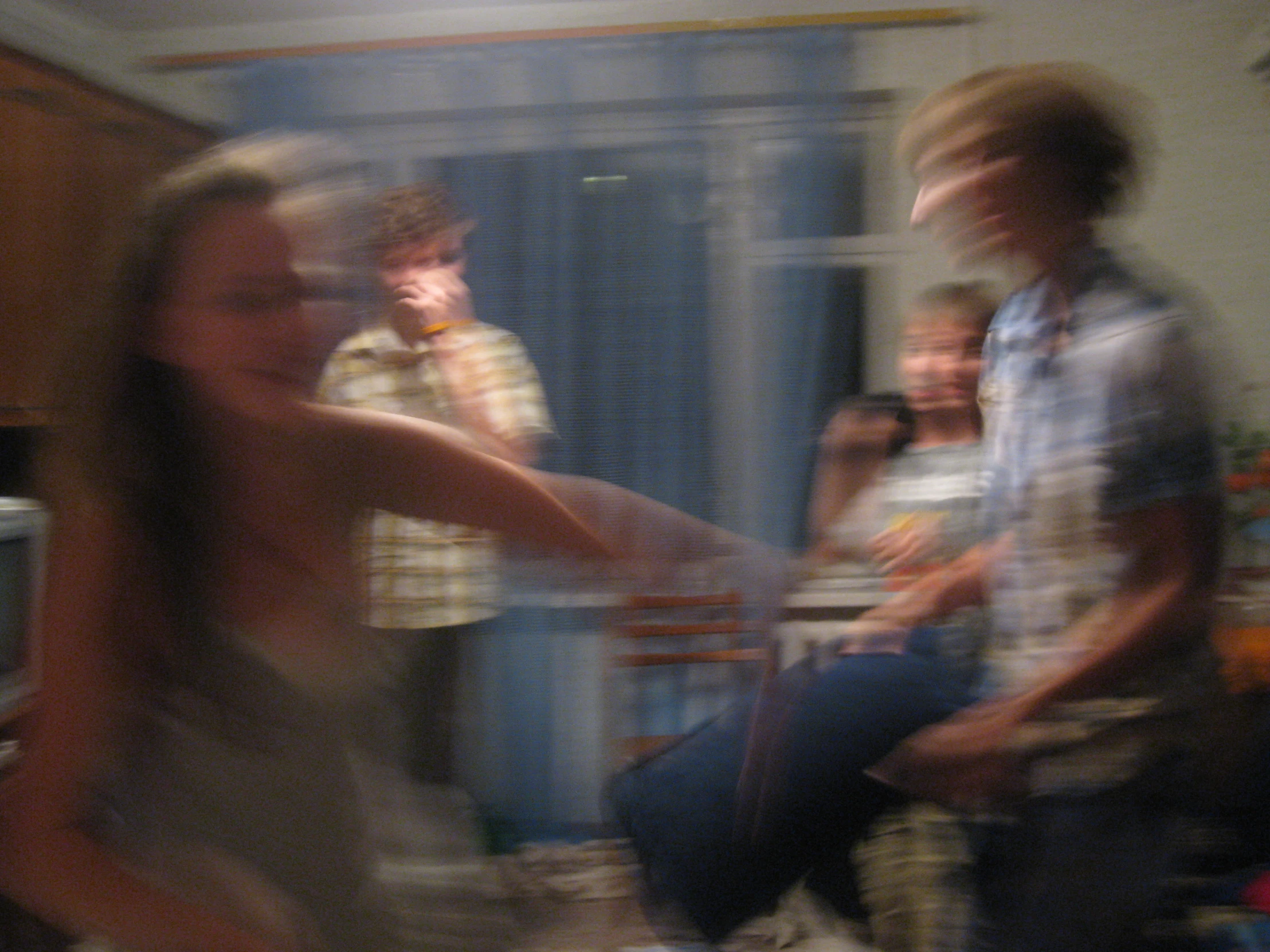 four people in a living room playing video games