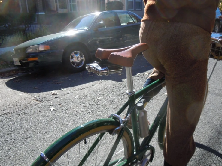 a person in brown pants standing on the front wheel of a bike