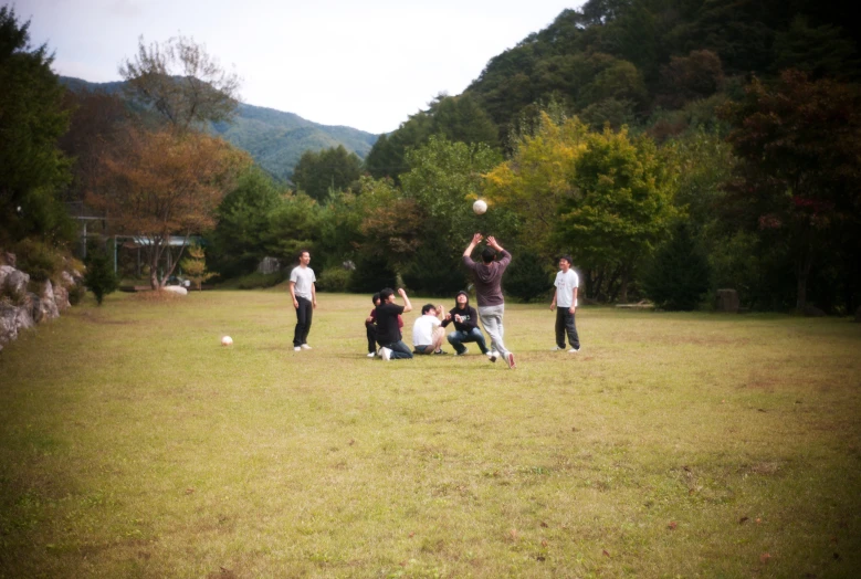 two men and a girl playing frisbee in a field