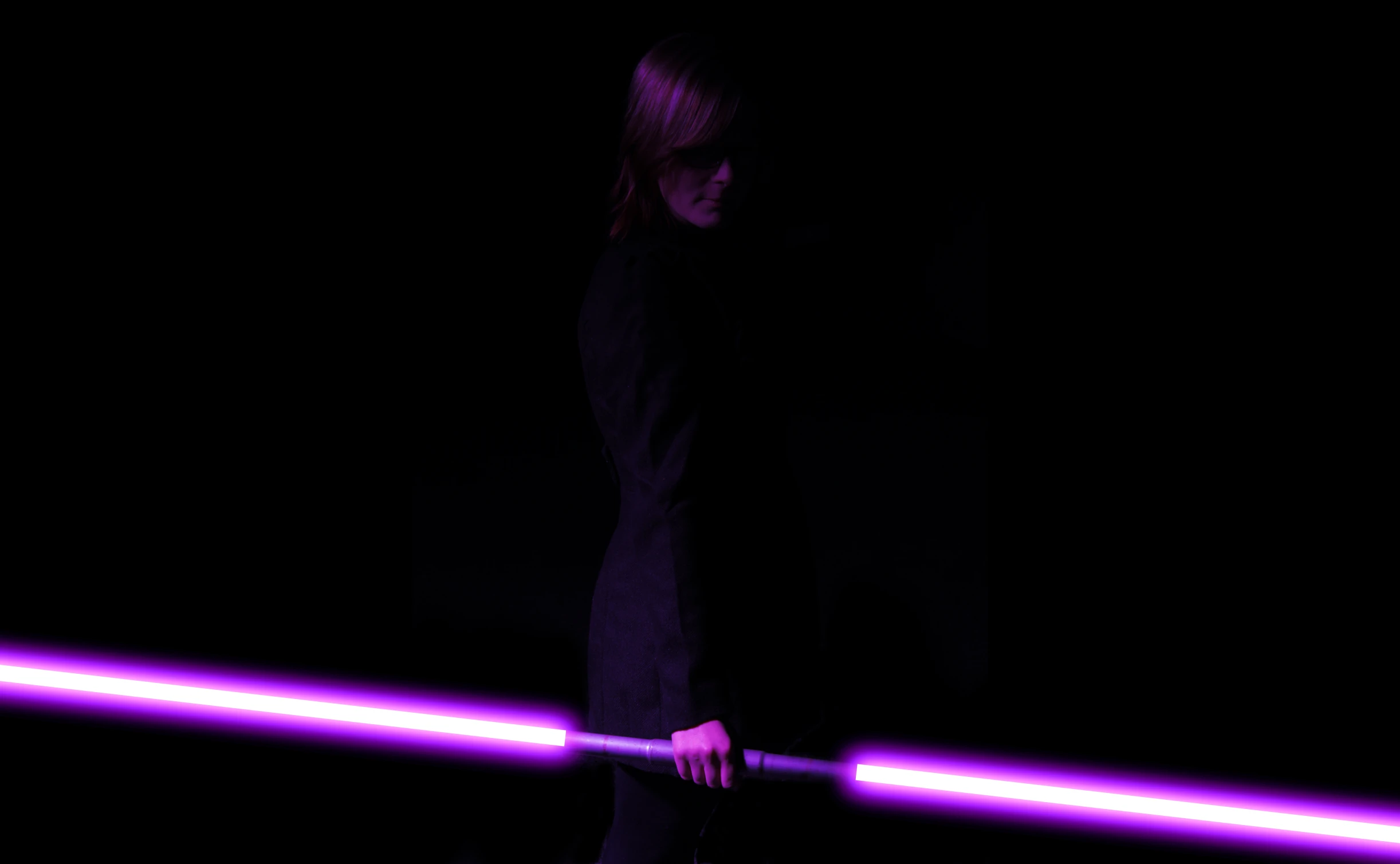 a woman with light saber in hand at night