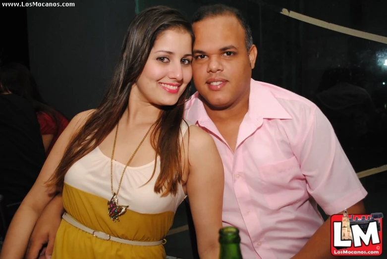 man and woman pose for camera at party