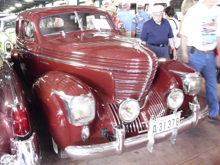 a red antique car is on display inside