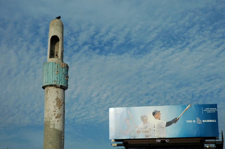 billboard advertising for baseball against a blue sky