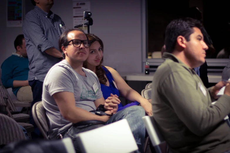 three people sitting next to each other while playing a video game