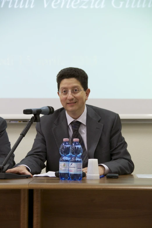 two men sitting next to each other at a conference table